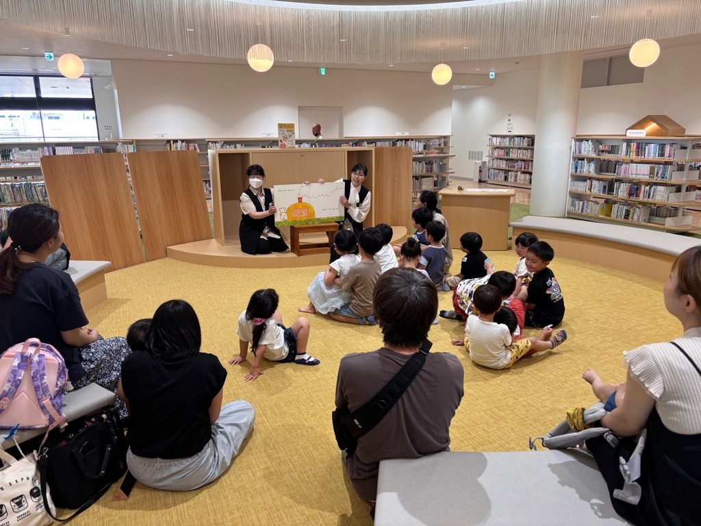 図書館職員の方の読み聞かせを聞く子どもたち