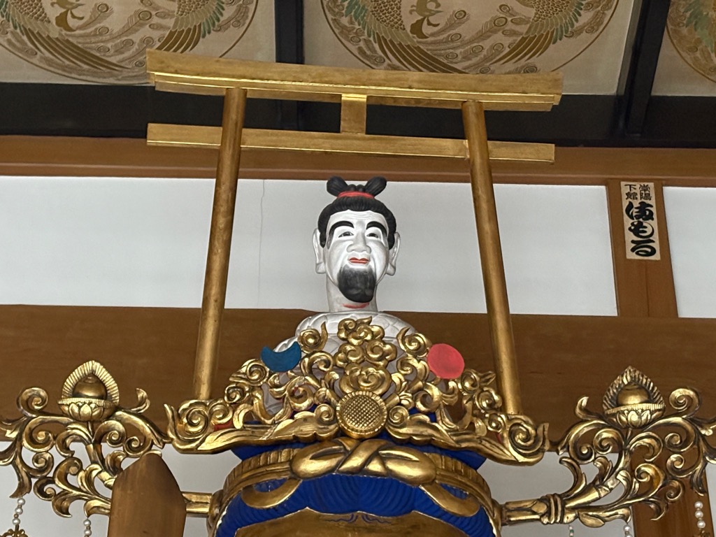 長蓮寺の仏像の頭にある人面の白ヘビの画像