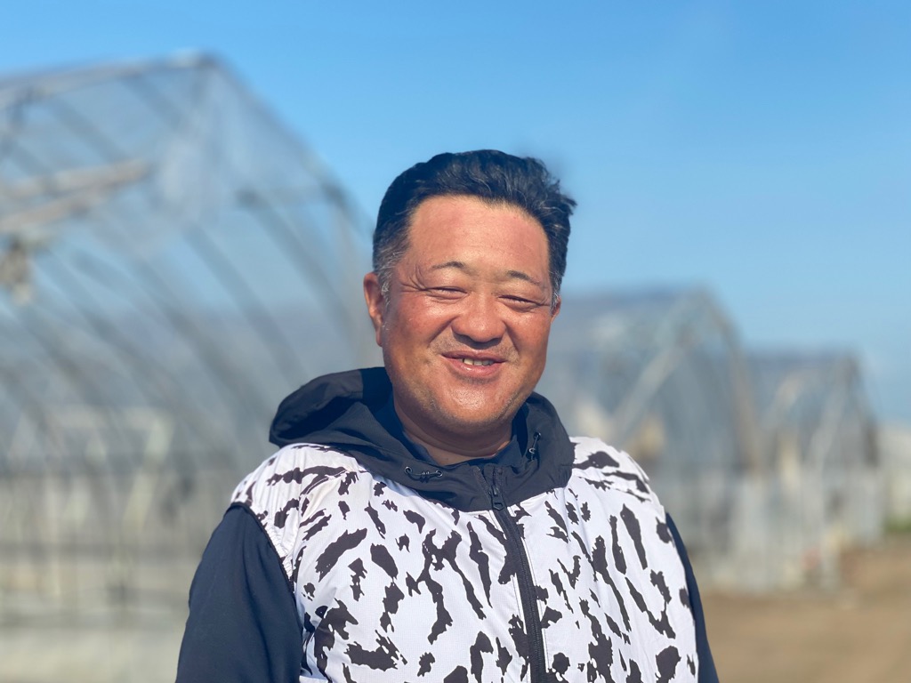 塚田さんが正面を向いて微笑んでいる様子