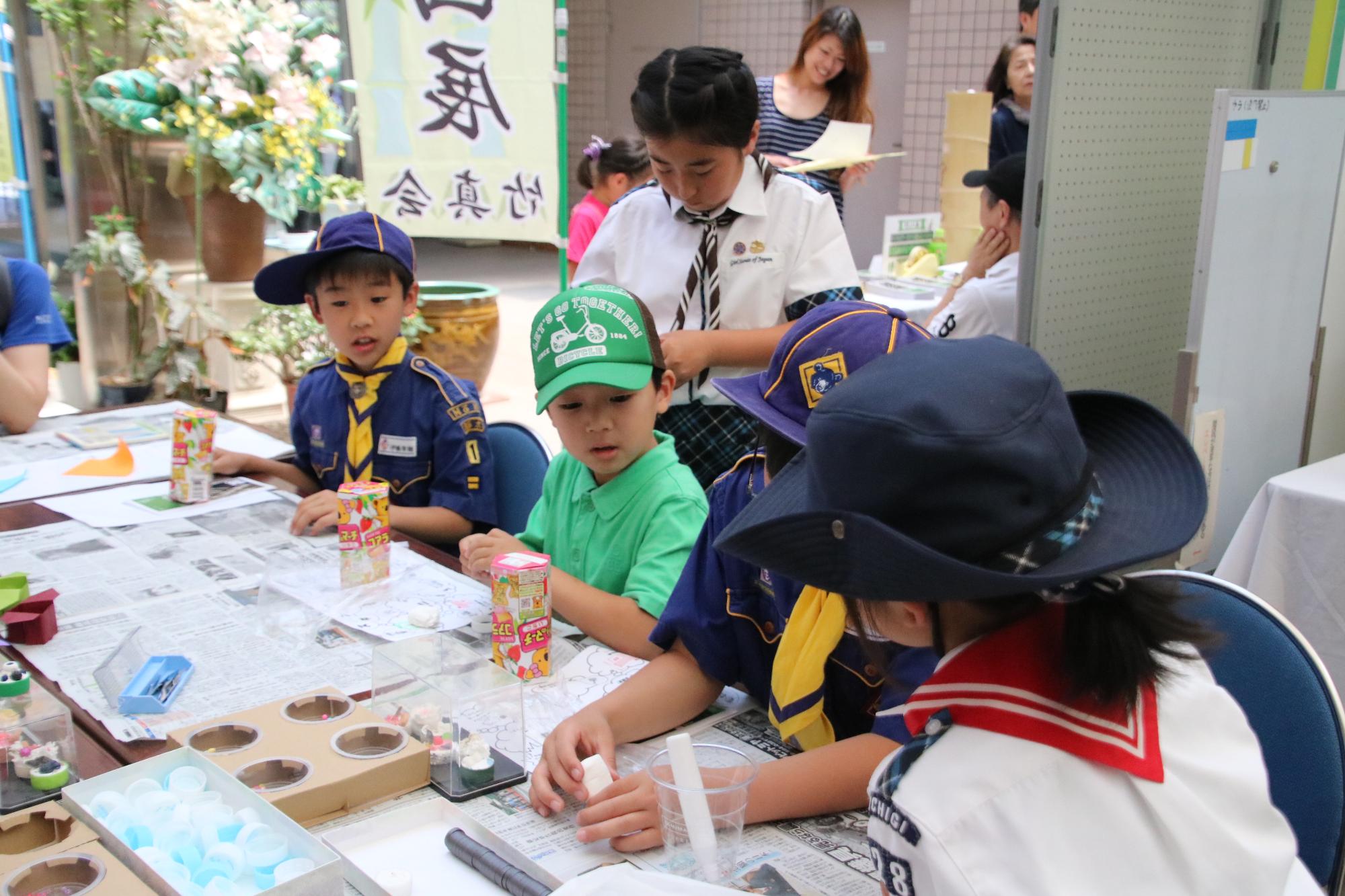 子供たちがお菓子の箱を使って工作している様子の写真