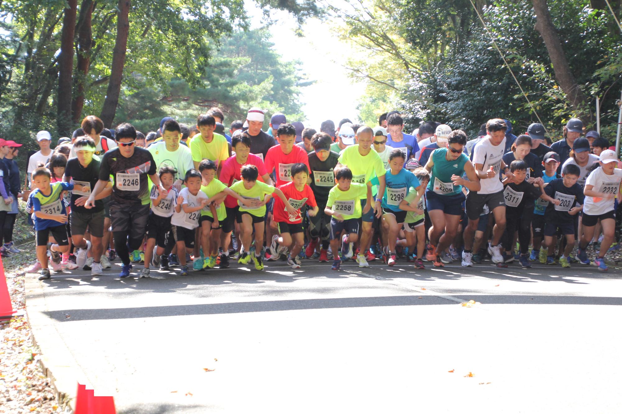 井頭公園で子供や大人たちが一斉に走り始めたマラソン大会の様子の写真
