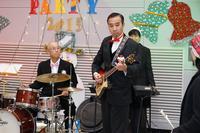 タキシードでギターを演奏する男性とドラムをたたく男性の写真