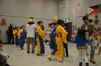 青と黄色の着物を着た女性とダンスをする人々の写真