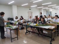 華道教室で講義を受ける女性たちと講師の写真