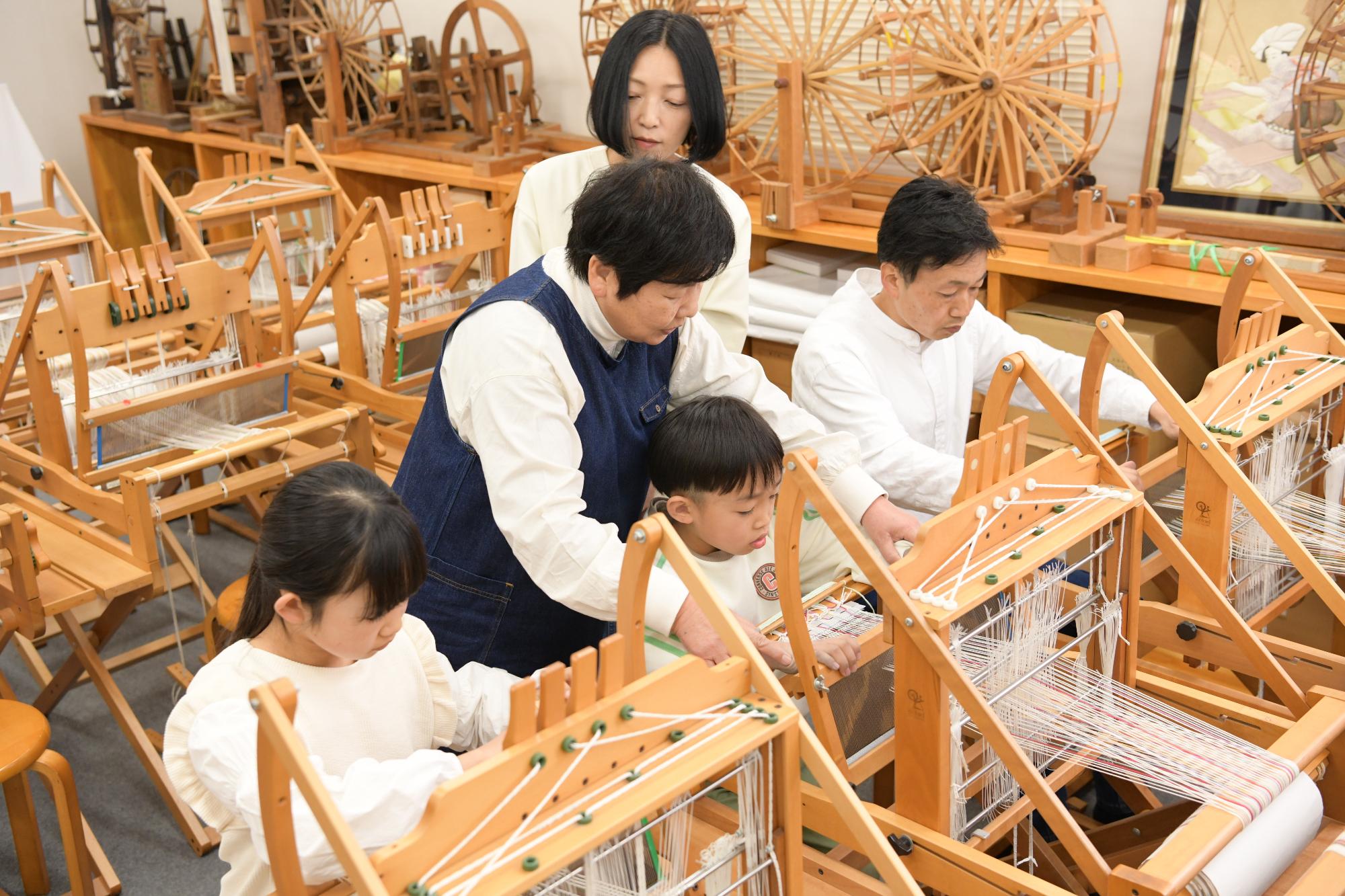 機織り体験をする家族