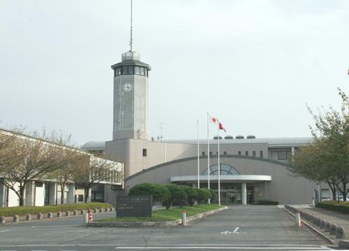 左側に高い時計塔があり中央に二宮コミュニティセンター、入り口前には国旗掲揚台がある全体の外観写真