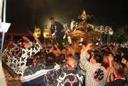 法被を着た担ぎ手達が神輿を担いでいる活気ある祭りの写真