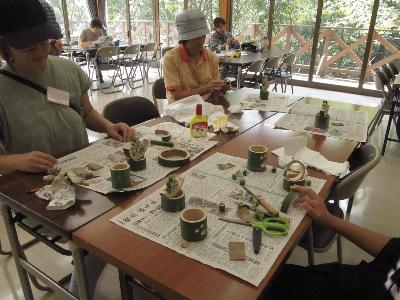 参加者がテーブルの上で竹を組み立てている写真です。