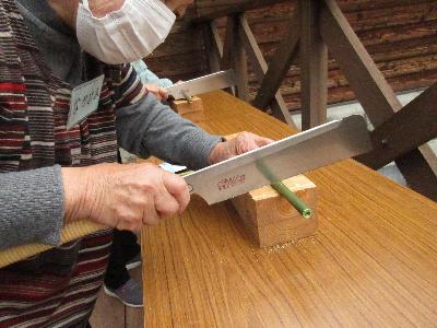 のこぎりでヤダケを切っている様子の写真です。