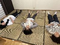 3人の参加者が仰向けに寝ている自分なおし体操の様子の写真