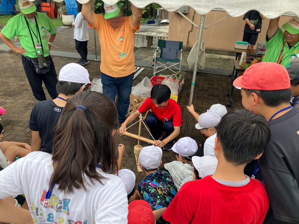 リーダーキャンプで竹水鉄砲つくりを補助している様子