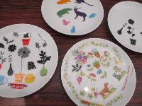 かわいらしいお花や動物などの絵が描かれた白いお皿が4枚並んでいる写真
