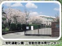 二宮町運動公園と二宮勤労者体育センターの外に満開の桜の木がある外観写真