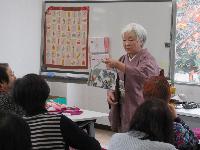 着物を着た講師の高崎光子先生が、受講生の前で話をしている様子の写真