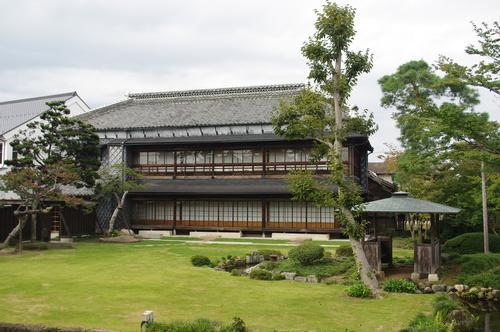 瓦屋根の2階建てで、建物前に芝生の庭が広がっている岡部記念館「金鈴荘」の外観写真