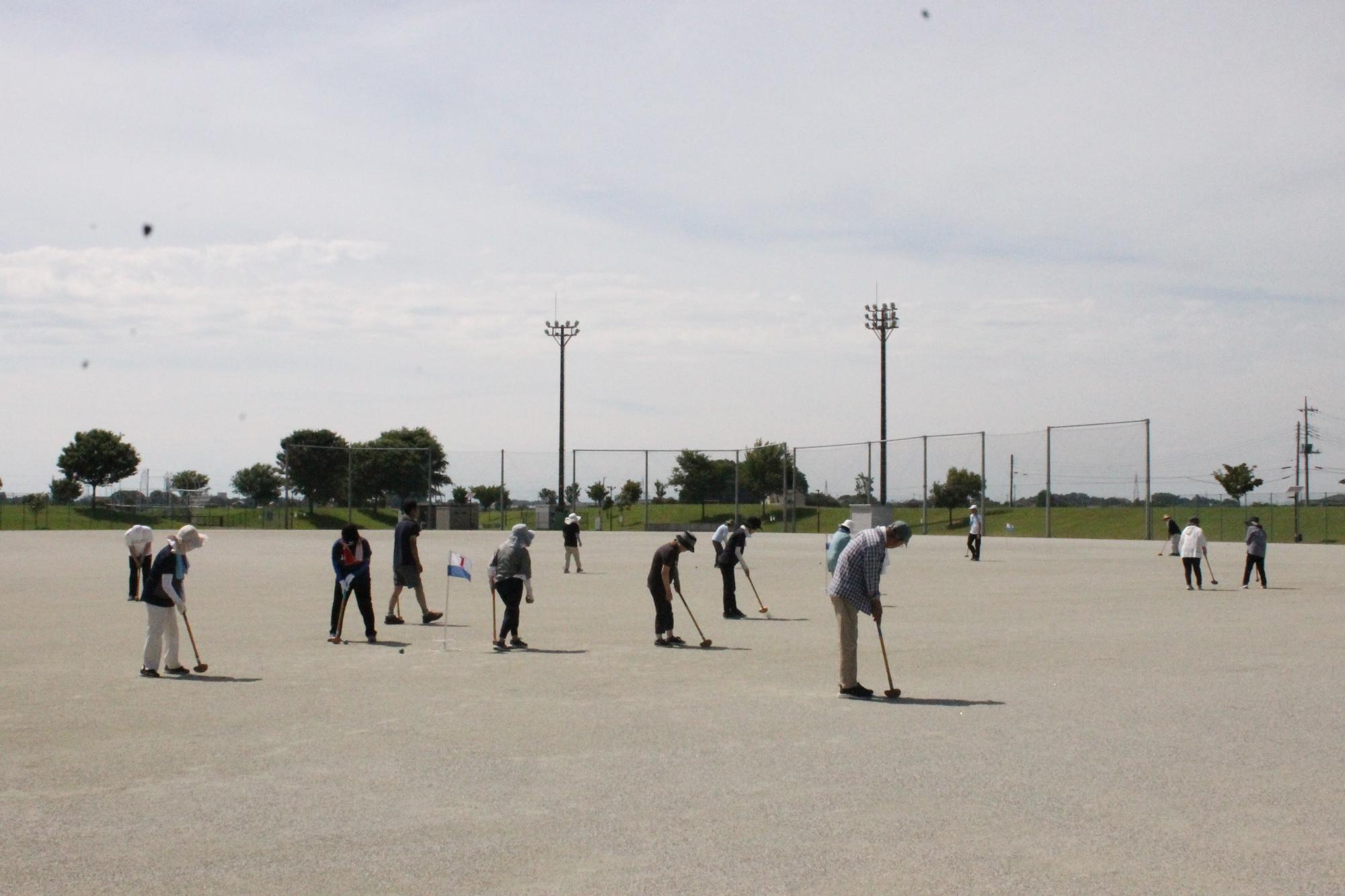 グラウンドゴルフの的に向かってボールを打つ受講生の皆さん