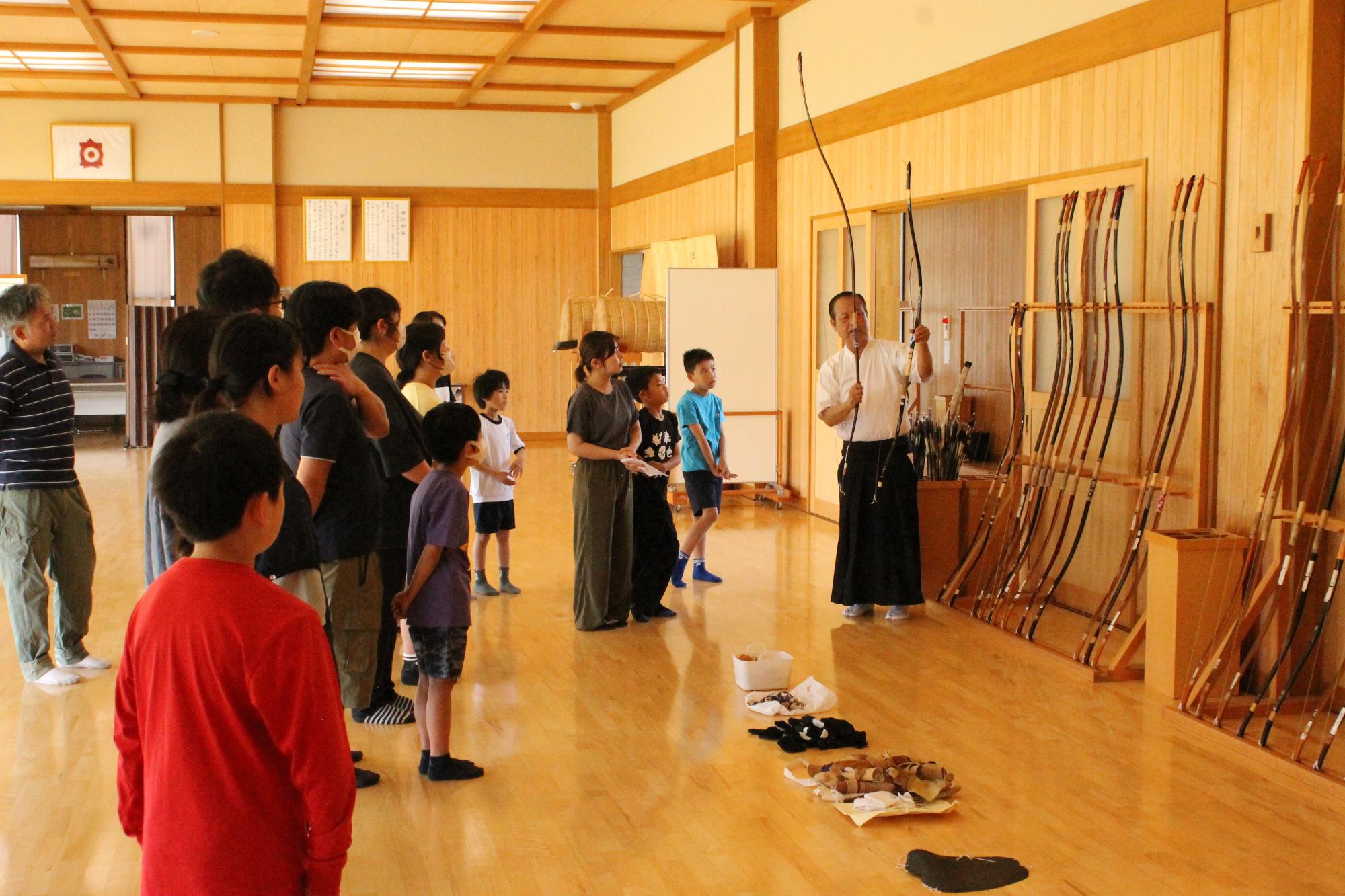 自分にあった弓の選び方を教える講師と聞き入る受講者