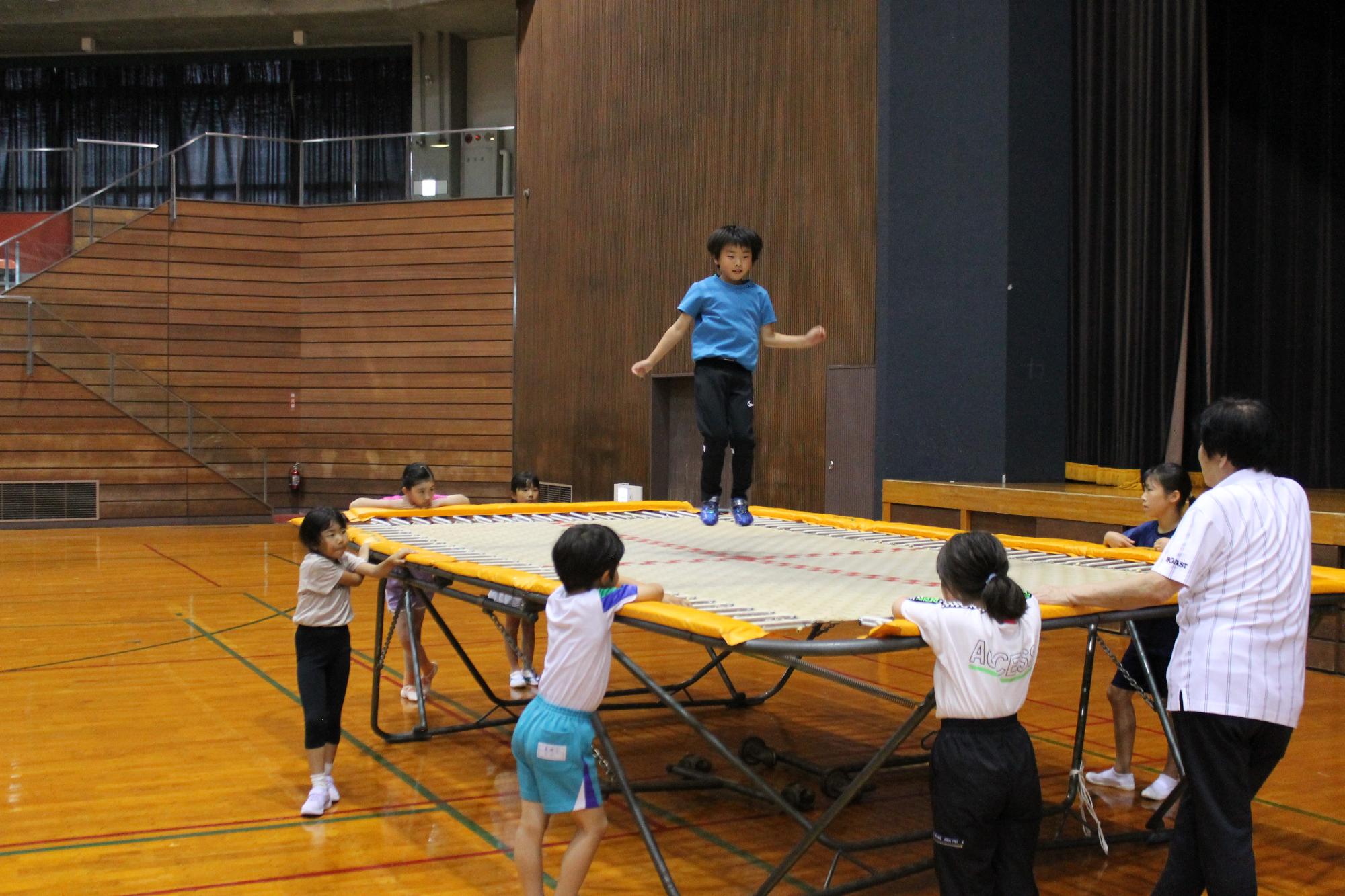 トランポリンの上でまっすぐ上手に飛ぶこども