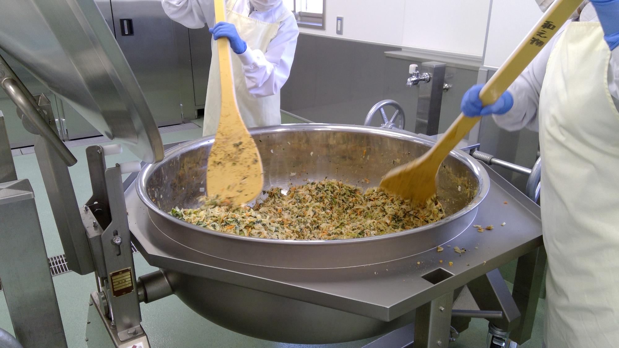 和え物釜に野菜を入れて調味をしている工程の写真