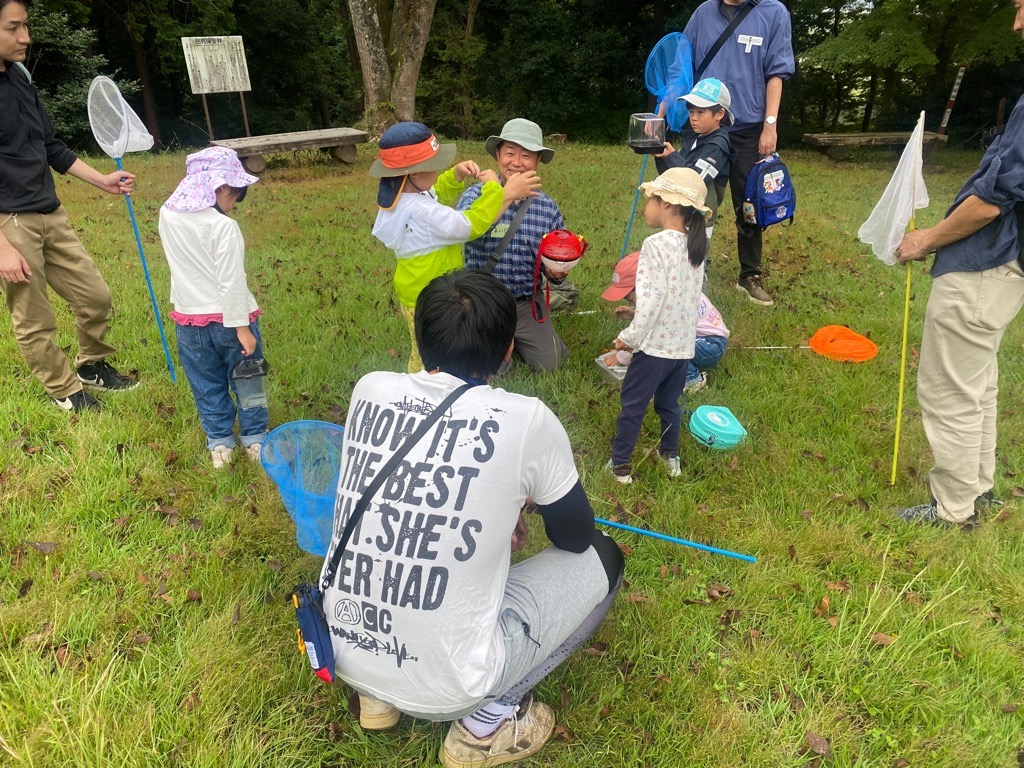自然観察指導員が参加者が捕まえた虫について説明する様子