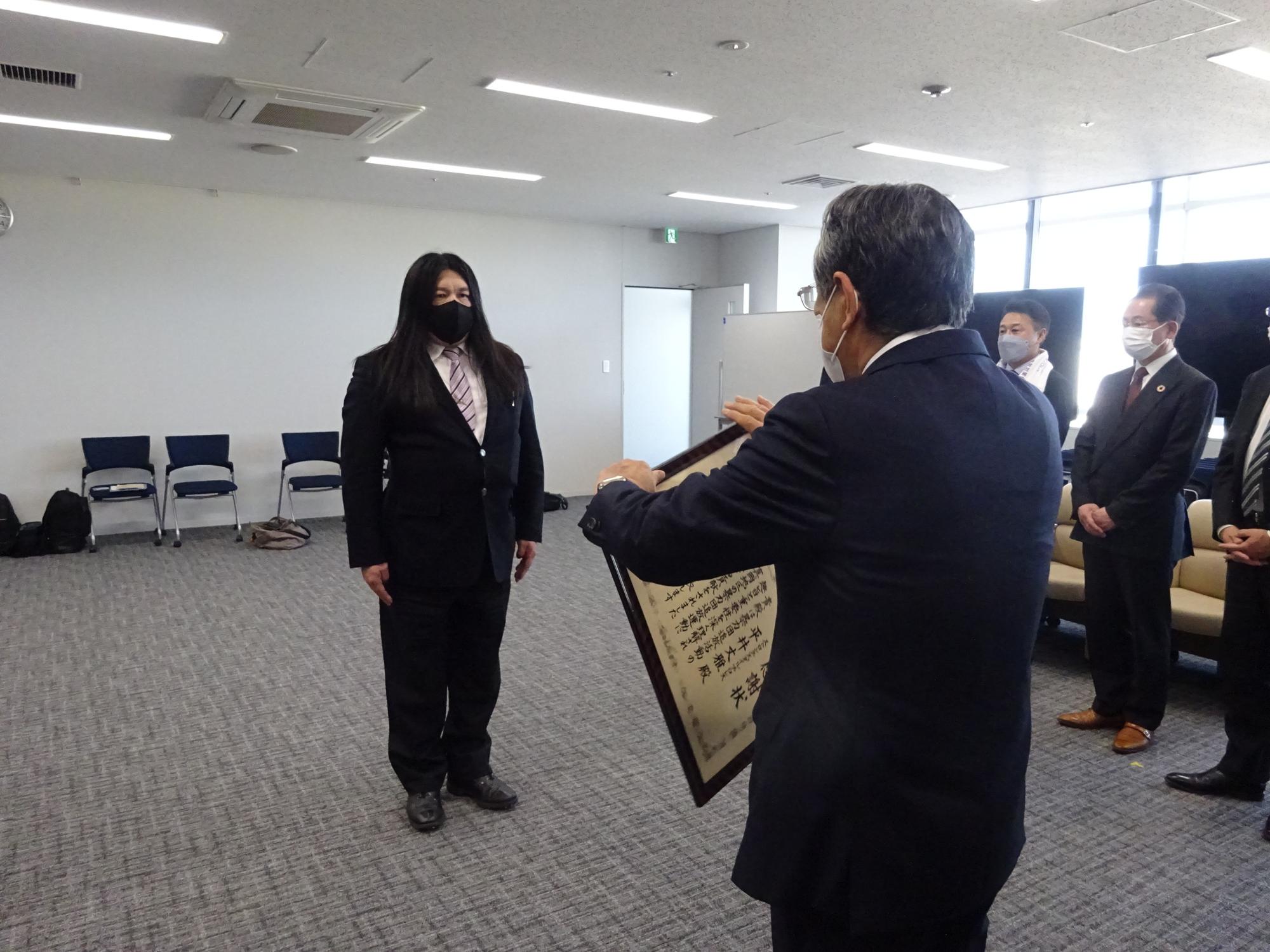 体格ががっしりとしている中村之洋さんに感謝状を渡そうとしている市長の写真