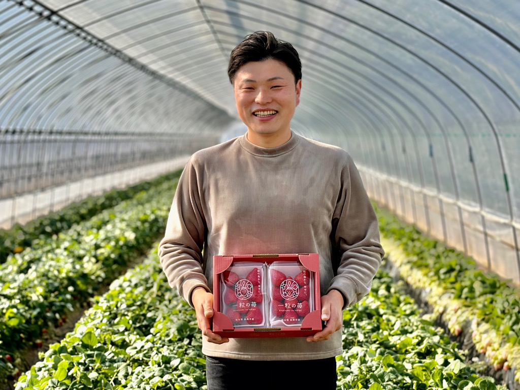 宇都木さんがいちごをもって笑っている写真